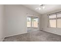 Spacious main bedroom with a ceiling fan, neutral paint, carpet, a window and sliding door access to the backyard at 418 E Fred Ave, Apache Junction, AZ 85119