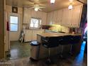 Cozy kitchen with white cabinets, a peninsula with seating, and vintage-style flooring at 5201 W Camelback Rd # Ofc, Phoenix, AZ 85031