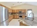 Stylish kitchen featuring stainless steel appliances, granite counters, and warm wood cabinetry at 604 W Villa Rita Dr, Phoenix, AZ 85023