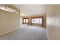 Spacious living room with plush carpeting, large windows overlooking the pool area, and neutral tones at 604 W Villa Rita Dr, Phoenix, AZ 85023