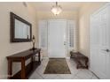 Inviting entryway with tiled floors, a console table, a mirror and a bench at 6820 W Angela Dr, Glendale, AZ 85308