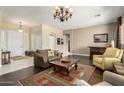 Cozy living room featuring hardwood floors, a chandelier, comfortable furniture and neutral paint at 6820 W Angela Dr, Glendale, AZ 85308