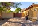 Exterior shot of a gated side yard with gravel, access to utilities and exterior light fixture at 6820 W Angela Dr, Glendale, AZ 85308