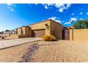 Tan home displaying a two-car garage, a walkway, and drought resistant landscaping at 7656 W Wagoner Rd, Glendale, AZ 85308