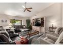 Bright living room with a vaulted ceiling, ceiling fan, large window, and comfortable seating arrangement at 8336 E Neville Ave, Mesa, AZ 85209