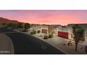 Street view of charming homes with well-maintained yards and desert landscaping at sunset at 8377 S Mountain Air Ln, Gold Canyon, AZ 85118