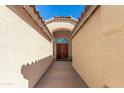 Inviting walkway leads to an elegant front entryway, featuring beautiful double doors and an arched entrance at 9728 E Pantera Ave, Mesa, AZ 85212
