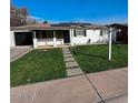 Charming single-story home with solar panels, a well-maintained lawn, and concrete driveway at 1017 S Lola Ln, Tempe, AZ 85281