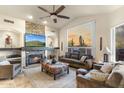 Living room with fireplace, comfortable seating, and view of the desert landscape at 11053 E Hedgehog Pl, Scottsdale, AZ 85262