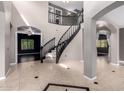Grand foyer with curved staircase, neutral walls, decorative tile flooring, and arched doorways at 1210 E Azure Sea Ln, Gilbert, AZ 85234