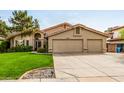 Beautiful home featuring a lush green lawn and a convenient three-car garage at 15027 N 61St Pl, Scottsdale, AZ 85254