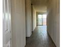 Interior view of a hallway featuring a tile floor, columns, and an outside view from the back patio door at 15784 W Beryl Ave, Waddell, AZ 85355