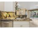 Kitchen sink with granite counters and a view of the living room, stainless steel dishwasher at 1701 E Colter St # 311, Phoenix, AZ 85016