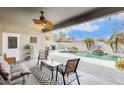 Inviting backyard patio with a fan, outdoor seating, and a refreshing pool area at 18360 N 169Th Ave, Surprise, AZ 85374