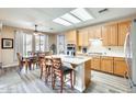 Bright kitchen featuring an island, natural wood cabinets, and a dining area with large windows at 18360 N 169Th Ave, Surprise, AZ 85374
