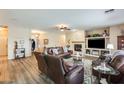 Cozy living room with wood floors, leather furniture, a fireplace, and a built-in entertainment center at 18360 N 169Th Ave, Surprise, AZ 85374
