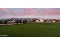 Scenic community featuring lush green space and mountain views at sunset at 21975 S 193Rd Way, Queen Creek, AZ 85142