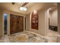 Elegant foyer featuring double doors, decorative rug, art niche, and arched doorways at 25031 N Paso Trl, Scottsdale, AZ 85255