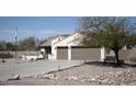 Single-story house with a two-car garage, desert landscaping, and a view of distant mountains at 3721 N Brindley Ave, Litchfield Park, AZ 85340