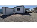Single Gathering home featuring a gravel yard, small shed, and a covered porch area at 4065 E University Dr # 471, Mesa, AZ 85205