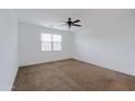This bedroom has neutral carpet, white walls, and a ceiling fan at 7109 E Gamebird Way, San Tan Valley, AZ 85143