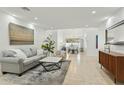 Bright, open living room with tile flooring, neutral decor, and a view into the dining area at 902 W Claremont St, Phoenix, AZ 85013
