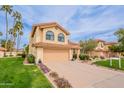 Charming two-story home featuring a well-manicured lawn, desert landscaping, and a two-car garage at 11731 N 91St Pl, Scottsdale, AZ 85260