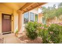 Inviting front porch entrance framed by flowering bushes, and a classic column at 11731 N 91St Pl, Scottsdale, AZ 85260