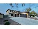 Charming two-story home with a three car garage, stone accents, and a concrete driveway at 16462 W Rowel Rd, Surprise, AZ 85387
