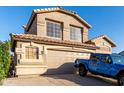 This desert home has a two-car garage and a glimpse of a blue Jeep parked in the drive at 1701 E Yukon Dr, Phoenix, AZ 85024