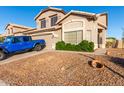 Exterior view of a well-kept home with a two-car garage, tidy landscaping, and desert rock in the front yard at 1701 E Yukon Dr, Phoenix, AZ 85024