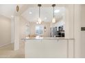 Bright kitchen with granite countertops, stainless steel appliances, and a breakfast bar overlooking the dining area at 18668 N Lariat Ct, Surprise, AZ 85387