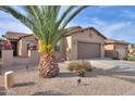 Inviting single-story home boasting a tile roof, a brown two-car garage and desert landscaping at 2611 E San Simeon Dr, Casa Grande, AZ 85194