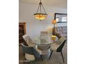 Inviting dining area with a glass-top table, unique chandelier, and comfortable seating at 311 E Lancaster Ct, Florence, AZ 85132