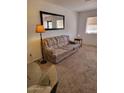Cozy living room with neutral carpet, accent lamp, and large mirror, creating a comfortable space at 311 E Lancaster Ct, Florence, AZ 85132