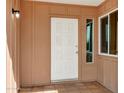 Close-up of the front door entrance featuring a white door and a side window on a tile porch at 3222 W Hearn Rd, Phoenix, AZ 85053