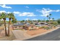 Wide shot of a charming single-story home featuring solar panels, desert landscape, and spacious front yard at 3222 W Hearn Rd, Phoenix, AZ 85053