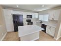Well-lit kitchen with modern black appliances, white cabinets, and a center island at 4908 N 110Th Dr, Phoenix, AZ 85037