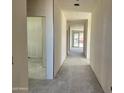 Hallway is long with white walls and concrete floors leading to sliding glass doors at the end at 5639 W Summerside Rd, Laveen, AZ 85339