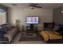 Comfortable living room with multiple seating areas, neutral walls, and a ceiling fan at 5684 S 237Th Dr, Buckeye, AZ 85326