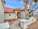 Inviting front entrance with a walkway leading to a wooden door, complemented by desert landscaping at 6704 W Topeka Dr, Glendale, AZ 85308