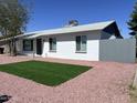 A cozy home featuring manicured grass, easy-care rock landscaping, and a freshly painted exterior at 7426 W Beryl Ave, Peoria, AZ 85345