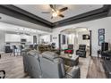 Open concept living room featuring a tray ceiling, gray leather furniture and seamless kitchen access at 854 S Del Rio Ct, Apache Junction, AZ 85120