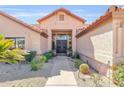 Close-up of the home's inviting entrance, featuring a tile walkway with stone landscaping at 8935 E Larkspur Dr, Scottsdale, AZ 85260