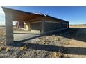 A close exterior shot of the block building's construction, detailing the concrete patio and attached wooden awning at 9600 S 393Rd Ave, Tonopah, AZ 85354