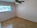 Cozy bedroom with neutral walls, laminate flooring, a window and a ceiling fan at 9638 W Cinnabar Ave # B, Peoria, AZ 85345