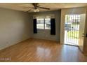 Inviting living room featuring wood floors, a ceiling fan, and a view through the window to the outside at 9638 W Cinnabar Ave # B, Peoria, AZ 85345