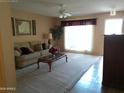 Comfortable living room with neutral colors, plush carpet, and ample natural light at 10327 W Prairie Hills Cir, Sun City, AZ 85351