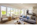Well-lit living room with large windows overlooking the backyard, a sofa, and stylish decor at 10640 E Mercer Ln, Scottsdale, AZ 85259