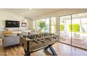 Spacious living area with a foosball table, large sliding glass doors to the backyard, and stylish furniture at 10640 E Mercer Ln, Scottsdale, AZ 85259